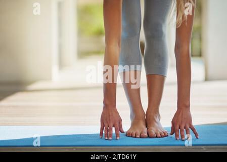 Preparandosi per un workout. Una donna irriconoscibile che allunga prima del suo workout. Foto Stock