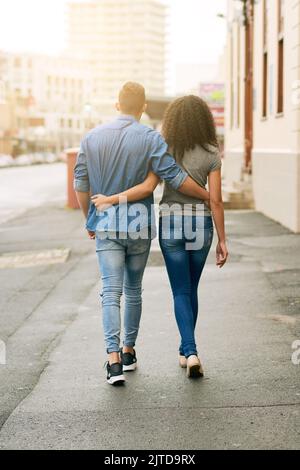 E vissero felici e contenti... Rearview ha girato di una giovane coppia che camminava in città. Foto Stock