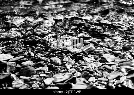 Arcobaleno rocce multicolore nel torrente delle valanghe che conduce verso il lago McDonald al Glacier National Park, Montana, USA Foto Stock