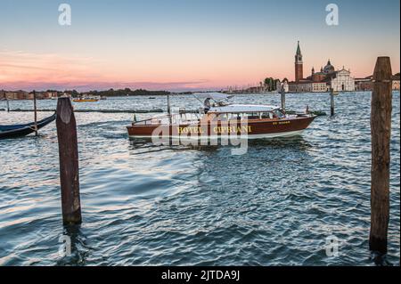 Venezia, Italia. 21st ago, 2022. Il taxi privato dell'Hotel Cipriani si trova all'ingresso del Canal Grande di fronte all'isola della Giudecca. Inizialmente annunciata per giugno 2022, la tassa di ingresso per i viaggiatori di un giorno a Venezia sarà applicata solo a partire dal 16° gennaio 2023. Stordito dalla pandemia del 19 nel 2021, dalla fine delle restrizioni sanitarie in Italia nel 2022 fino a 110.000 giorni di turisti visitano la città, mentre la popolazione permanente della città è stimata in circa 50.000 persone. L'introduzione di tasse e restrizioni per i visitatori sui siti naturali e culturali più frequentati, noti come Foto Stock