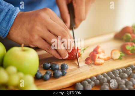 Prendere una fetta della vita sana, un uomo che prepara uno spuntino sano e fruttato. Foto Stock