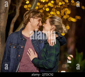 Non possono smettere di guardare gli occhi gli uni verso gli altri: Una giovane coppia sta per baciarsi mentre si trova in città. Foto Stock