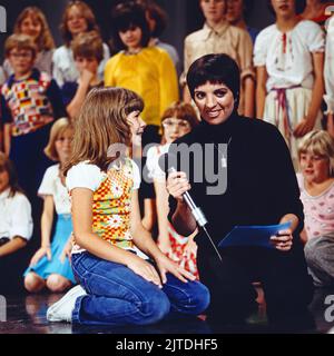 Liza Minelli, amerikanische Sängerin und Schauspielerin, im Bild mit Kindern bei einem Auftritt in Deutschland, 1987. Liza Minelli, cantante e attrice americana, raffigurata con i bambini in una rappresentazione in Germania, 1987. Foto Stock