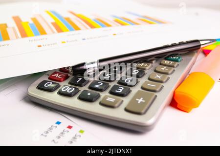 documentare il foglio grafico a colori per la presentazione in ufficio con la calcolatrice delle attrezzature, la penna, la penna a colori evidenziata Foto Stock