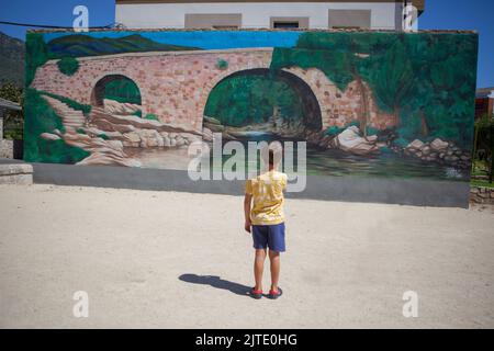 Losar, Spagna - 23th agosto 2022: Parete decorata con graffiti raffigurante il ponte Cuartos a Losar de la vera, Caceres, Estremadura, Spagna Foto Stock