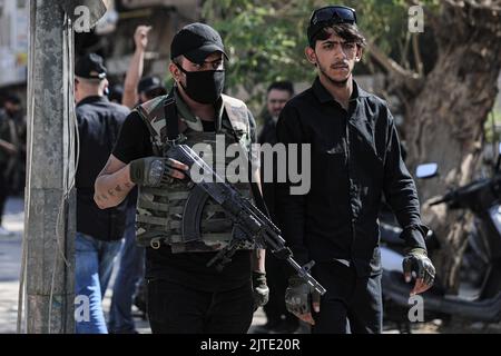 Baghdad, Iraq. 30th ago, 2022. Membro armato di Saraya al-Salam, l'ala militare collegata al clerico sciita iracheno Muqtada al-Sadr è vista durante gli scontri con le forze di sicurezza irachene nella zona verde dell'Iraq. Fonti di sicurezza e assistenza medica irachene hanno riferito che almeno 25 persone sono state uccise e 450 feriti dopo i disordini scoppiati il giorno precedente. Credit: Ameer al-Mohammedawi/dpa/Alamy Live News Foto Stock