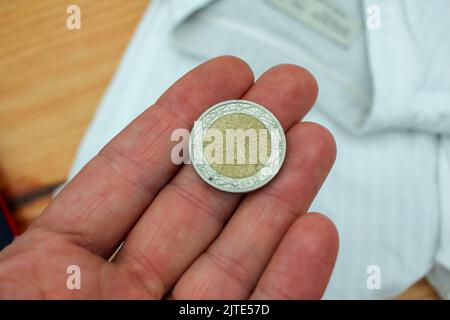 una moneta da due euro nel palmo della mia mano per pagare i vestiti Foto Stock