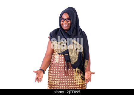 Donna musulmana matura che indossa occhiali, in piedi e sorridente alla macchina fotografica. Foto Stock