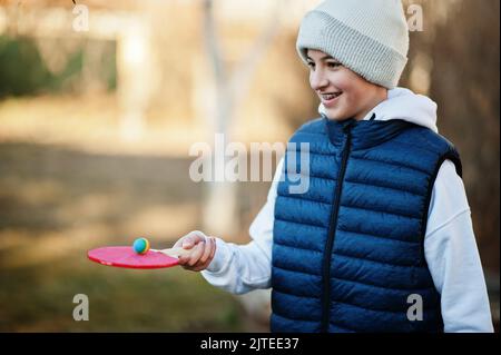 Il gioco del ragazzo tiene la palla sul racket. Foto Stock