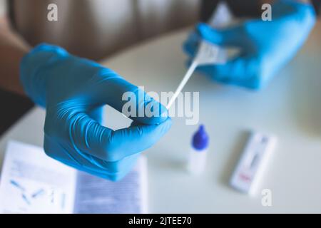 Processo di esame rapido dell'antigene cocvido del coronavirus AG PCR a domicilio, kit per il prelievo di tamponi COVID-19, una provetta per il prelievo di patie NP OP Foto Stock