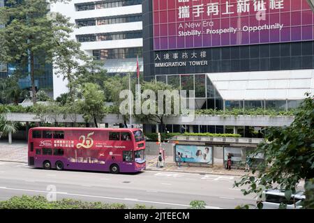Hong Kong consegna 25th ° anniversario di pubblicità, su Immigration Tower e autobus di passaggio, Connaught Road, Wanchai, Hong Kong, SAR, Cina Foto Stock