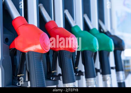 le pistole di rifornimento sono appese in fila ad una stazione di servizio. vista laterale dal basso Foto Stock