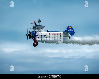 Aerosuperbatics wingwalker all'Eastbourne Airshow, l'unica squadra professionista di wingwalking al mondo. Aircraft è un biplano Boeing Stearman del 1940s Foto Stock