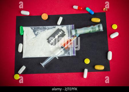 Vista dall'alto piatto posare molti farmaci vari pronti per l'uso. Siringa con pillole e rasoio. Foto Stock