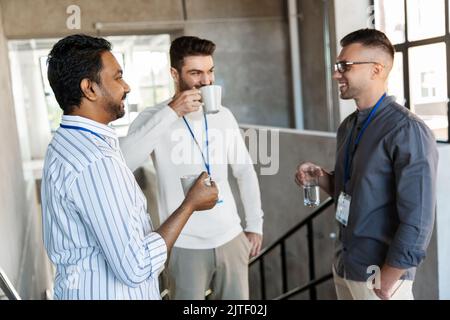 uomini d'affari che bevono caffè da asporto in ufficio Foto Stock