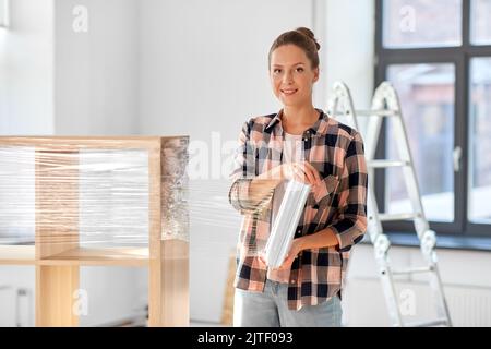 donna felice imballaggio scaffale e il trasferimento a nuova casa Foto Stock