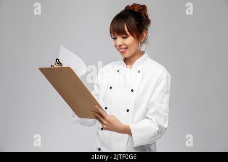 sorridente cuoco femminile con appunti Foto Stock
