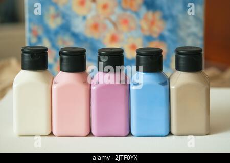 Set di vasetti di pittura acrilica pastello in tela bianca. Foto Stock