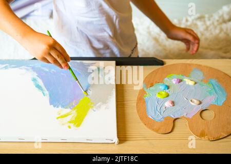 Pittura bambino su tela con pittura acrilica. Foto Stock