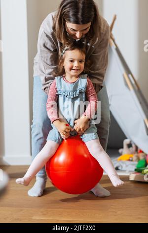 madre e figlia rimbalzano sulla tramoggia a casa Foto Stock