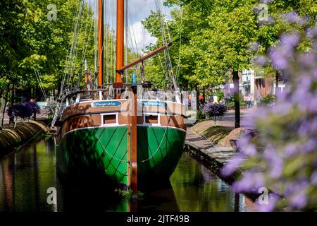 Papenburg, Germania. 30th ago, 2022. La replica di un bracciale storico, una nave da carico tipica di Papenburg, chiamata 'Margaretha von Papenburg' è ormeggiata con il sole nel canale principale nel centro della città. Credit: Hauke-Christian Dittrich/dpa/Alamy Live News Foto Stock