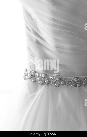 Primo piano della cintura in perla e diamante sull'abito da sposa bianco. Foto Stock