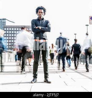 Indipendenza. Un individuo che si trova con fiducia contro il flusso del suo ambiente convenzionale. Foto Stock