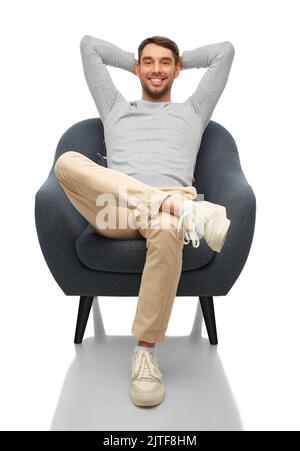 felice uomo sorridente seduto in sedia Foto Stock