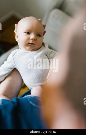 Primo piano del padre che tiene un figlio neonato (0-1 mesi) a casa Foto Stock
