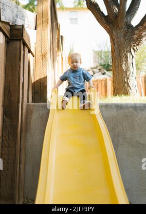 Ragazzo (2-3) su scivolo nel parco Foto Stock