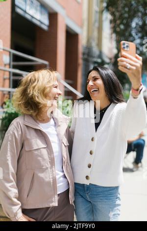 Sorridendo amici femmina che prendono selfie Foto Stock
