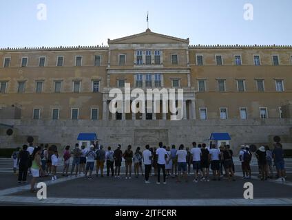 I turisti che assistono alla cerimonia delle Guardie presidenziali sul terreno del Parlamento ellenico in piazza Syntagma, Atene Grecia. Foto Stock