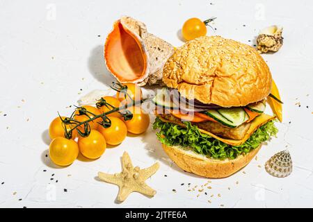 Hamburger di pesce fatto in casa. Ingredienti freschi, verdure mature, fast food. Una luce dura alla moda, ombra scura, decor marino, sfondo bianco stucco Foto Stock