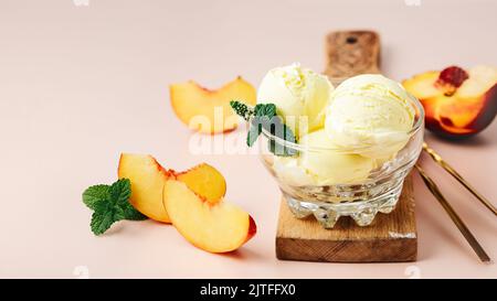 Cucchiaio di gelato alla pesca in un bicchiere. Foto Stock