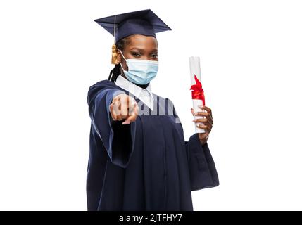 studente laureato in maschera con diploma Foto Stock