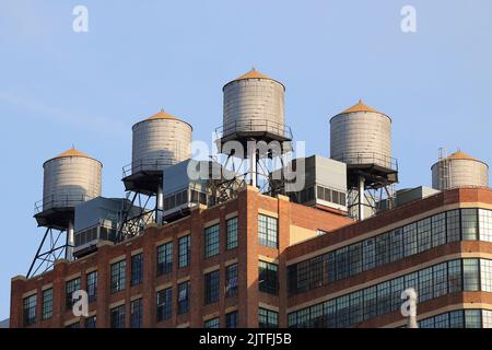 Serbatoi d'acqua in legno Rosenwach e unità di raffreddamento hvac sul tetto del magazzino Starrett-Lehigh trasformato in ufficio a New York. Foto Stock