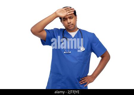 medico stressato o infermiera maschile in uniforme blu Foto Stock