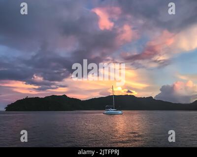 Spettacolare tramonto sull'oceano. Yacht vela calma acqua di mare sotto il cielo nuvoloso vibrante. Impressionante mare colorato. Splendida natura selvaggia durante l'alba. Splendida scena pittoresca. Viaggi, turismo Foto Stock
