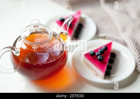 teiera di vetro con bevanda calda e torte con frutti di bosco. bevanda per dessert dolce Foto Stock