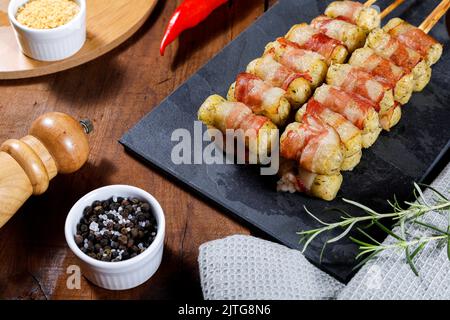 Spiedini di manioca avvolti in pancetta, medaglione di manioca. Foto Stock