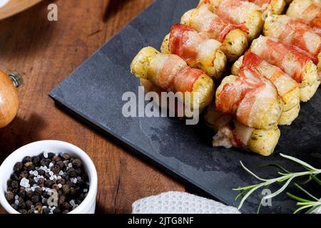 Spiedini di manioca avvolti in pancetta, medaglione di manioca. Foto Stock