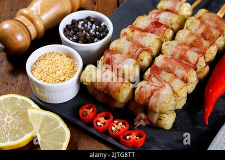 Spiedini di manioca avvolti in pancetta, medaglione di manioca. Foto Stock