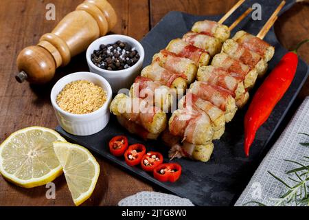 Spiedini di manioca avvolti in pancetta, medaglione di manioca. Foto Stock