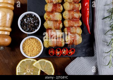 Spiedini di manioca avvolti in pancetta, medaglione di manioca. Foto Stock