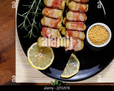 Spiedini di manioca avvolti in pancetta, medaglione di manioca. Foto Stock