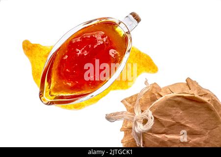 Marmellata di frutta dolce color arancio in recipiente di vetro e vasetto isolato su fondo bianco Foto Stock