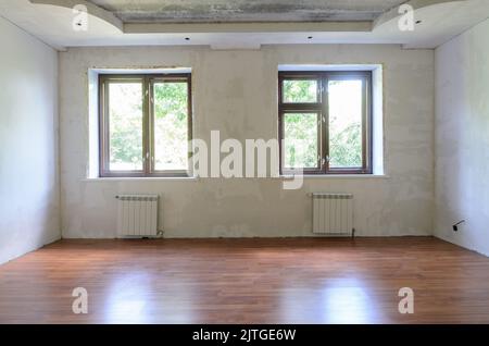 Interno della stanza vuota durante la ristrutturazione, vista parete con finestre Foto Stock