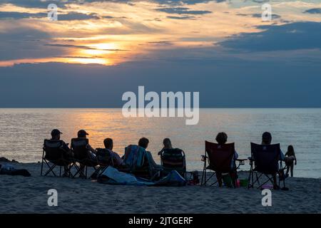 Union Pier, Michigan - i turisti si riuniscono sulle rive del lago Michigan per guardare il tramonto quasi ogni sera d'estate. Foto Stock