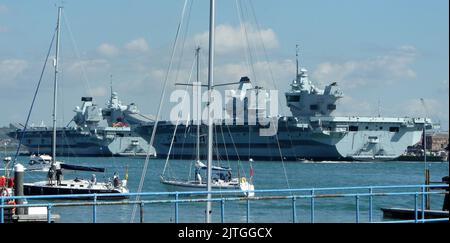 AJAXNETPHOTO. 26TH AGOSTO, 2022. PORTSMOUTH, INGHILTERRA. - PROBLEMA DEL VETTORE - HMS PRINCE OF WALES (A DESTRA), VISTO QUI ORMEGGIATO ALLA BASE NAVALE DI PORTSMOUTH, A EST DELLA NAVE GEMELLA HMS QUEEN ELIZABETH, DUE DELLE PIÙ GRANDI WASHIPS DELLA ROYAL NAVY (65.000 TONNELLATE), POCO PRIMA DI NAVIGARE NEGLI STATI UNITI PER PARTECIPARE A UN ESERCIZIO CONGIUNTO CON USN QUANDO SI È VERIFICATO UN PROBLEMA DI ALBERO DI PROPULSIONE A METÀ CANALE. FOTO: N.GRUNDY/AJAX RIF:DNG222608 1 Foto Stock