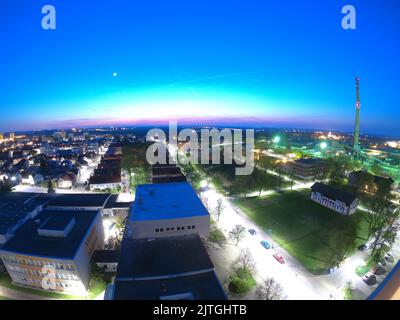 Vista aerea notturna del paesaggio della vecchia città industriale europea durante la luna piena, delle strade scintillanti a lunga esposizione, della città di Nymburk Foto Stock